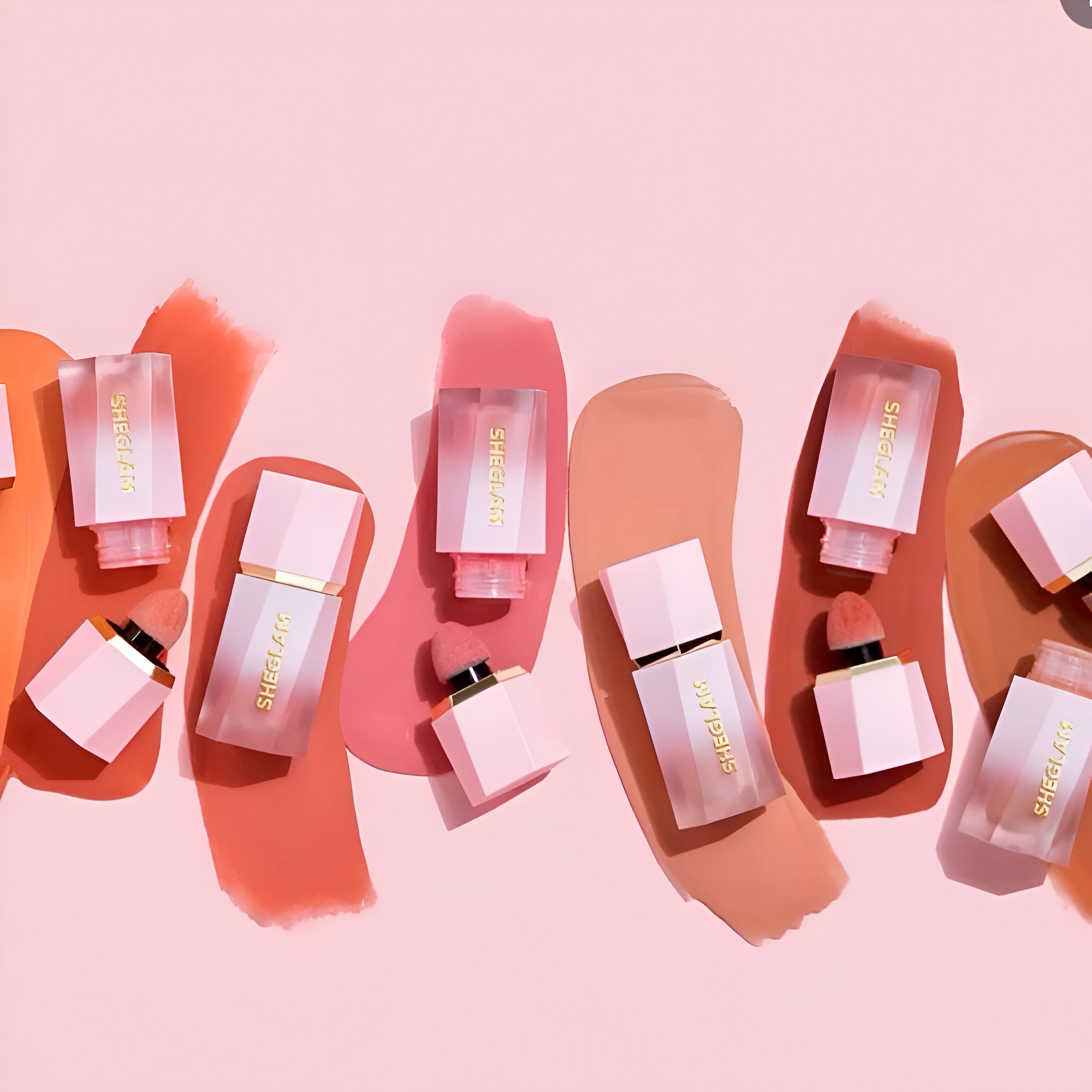 Pink perfume bottles with gold accents on a pink background